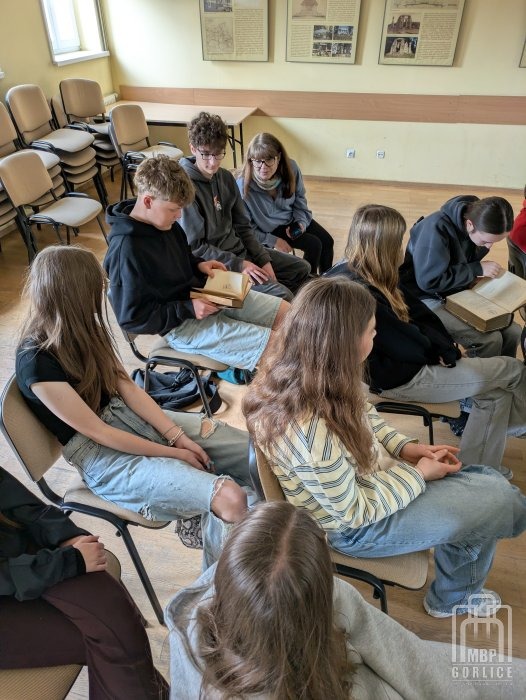 Biblioteka Gorlice, lekcja biblioteczna Uczniowie oglądają pond stuletnie książki